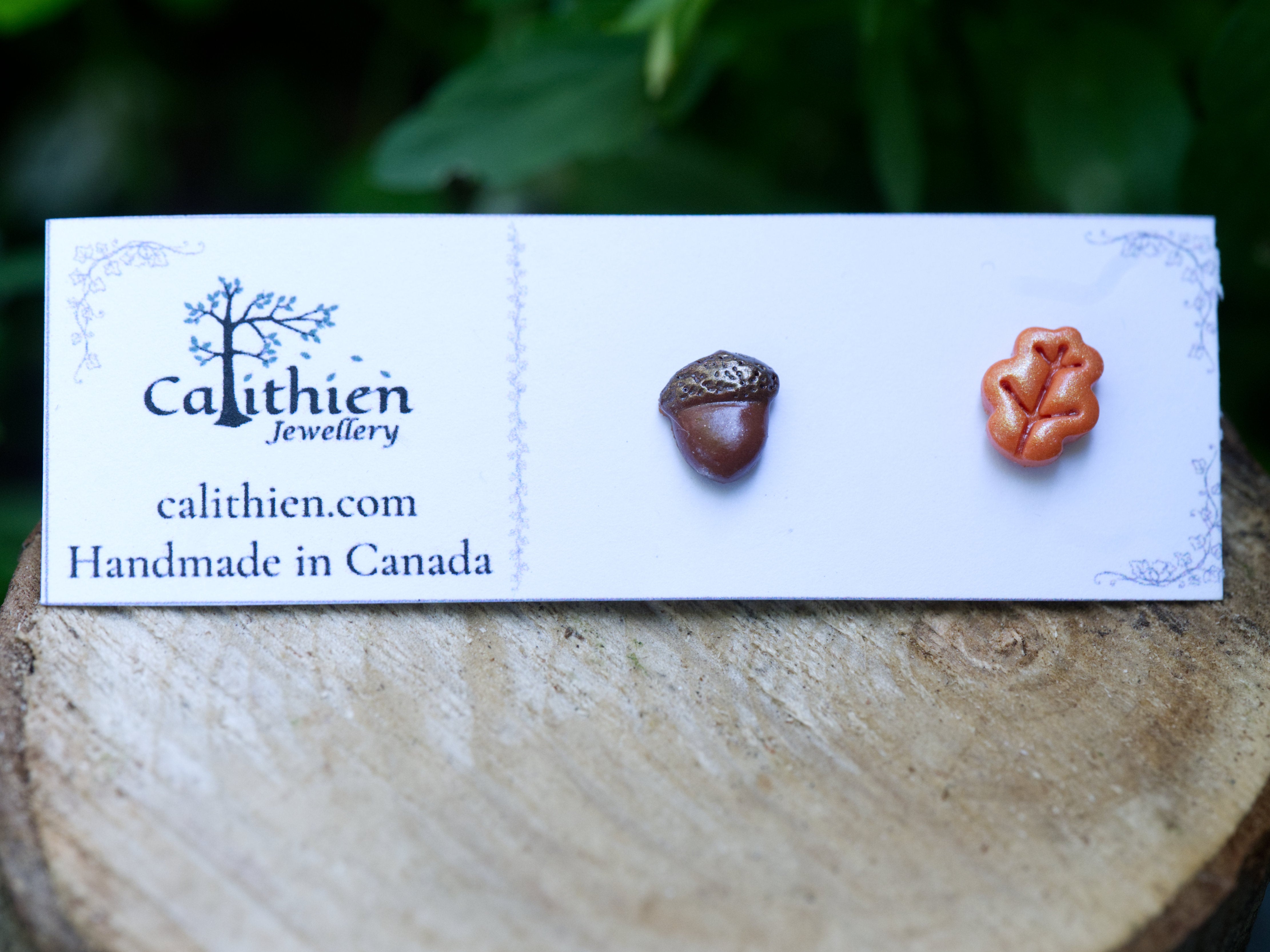 Mismatched oak leaf and acorn stud earrings on Calithien Jewellery branded display card reading Handmade in Canada