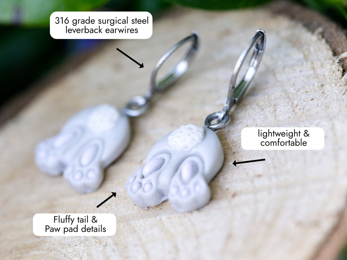 A close up photo of the bunny butt leverback earrings with callouts for the surgical steel earwires and their lightweight and comfortable design