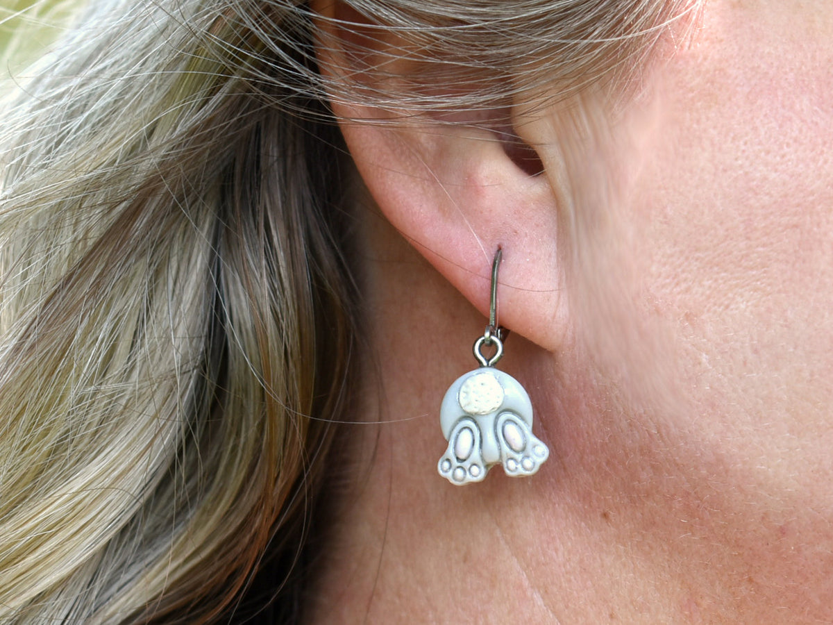 Grey bunny bum dangle earrings worn in the ear