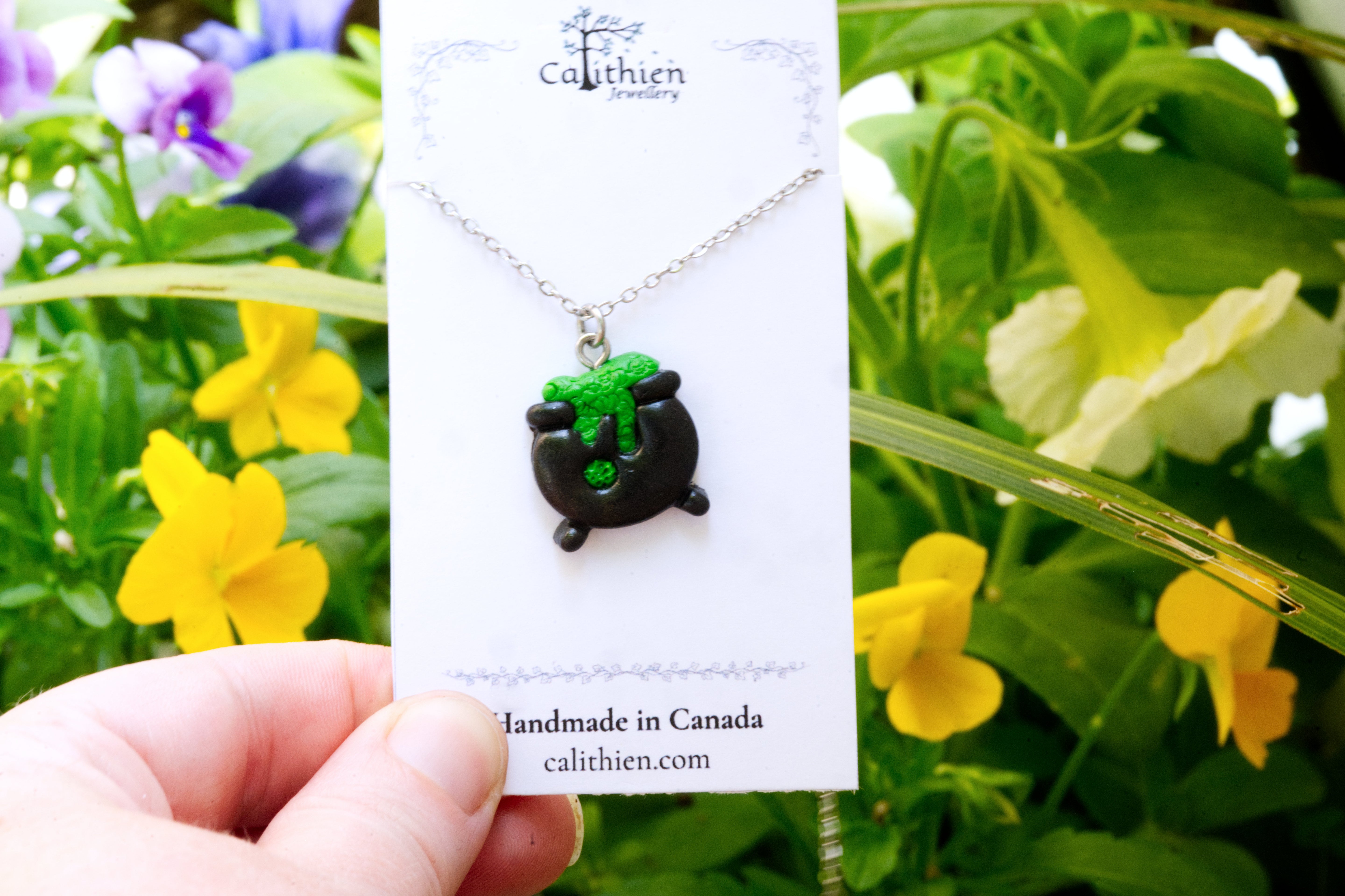 Cauldron pendant necklace held in fingers on Calithien Jewellery branded display card reading Handmade in Canada