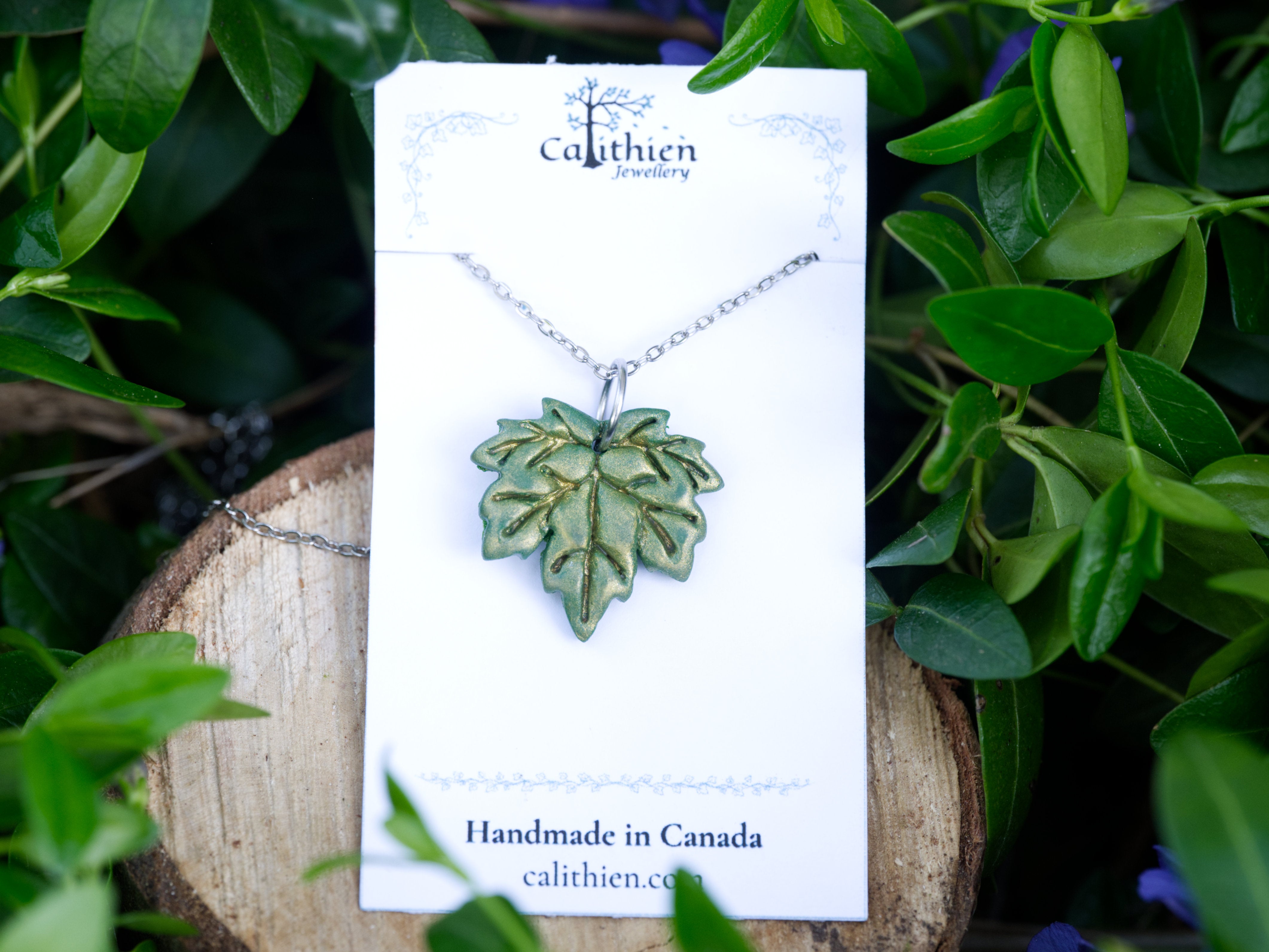 Green maple leaf pendant necklace on Calithien Jewellery branded display card reading Handmade in Canada