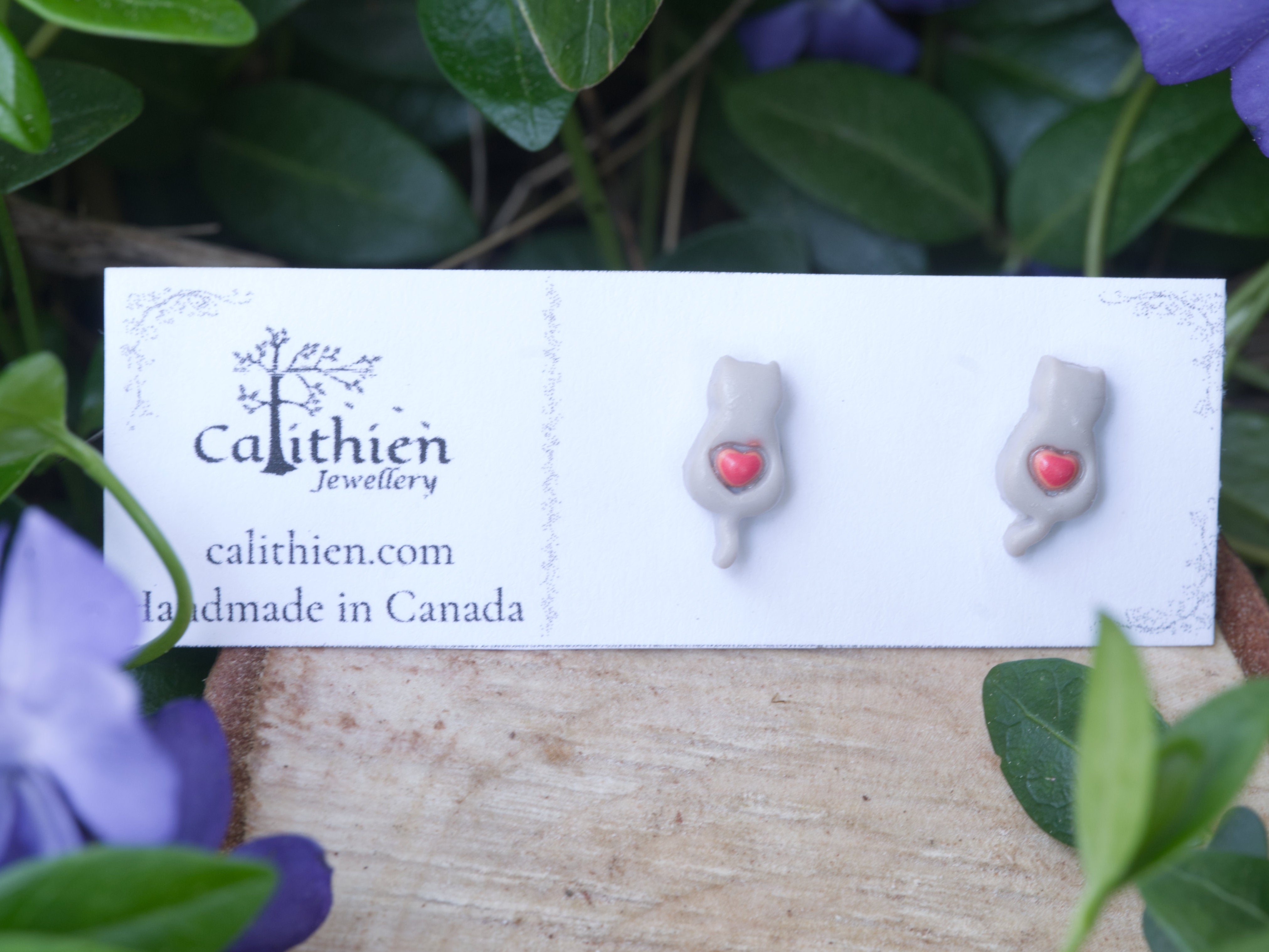 Grey cat stud earrings mounted on Calithien Jewellery branded display card reading Handmade in Canada