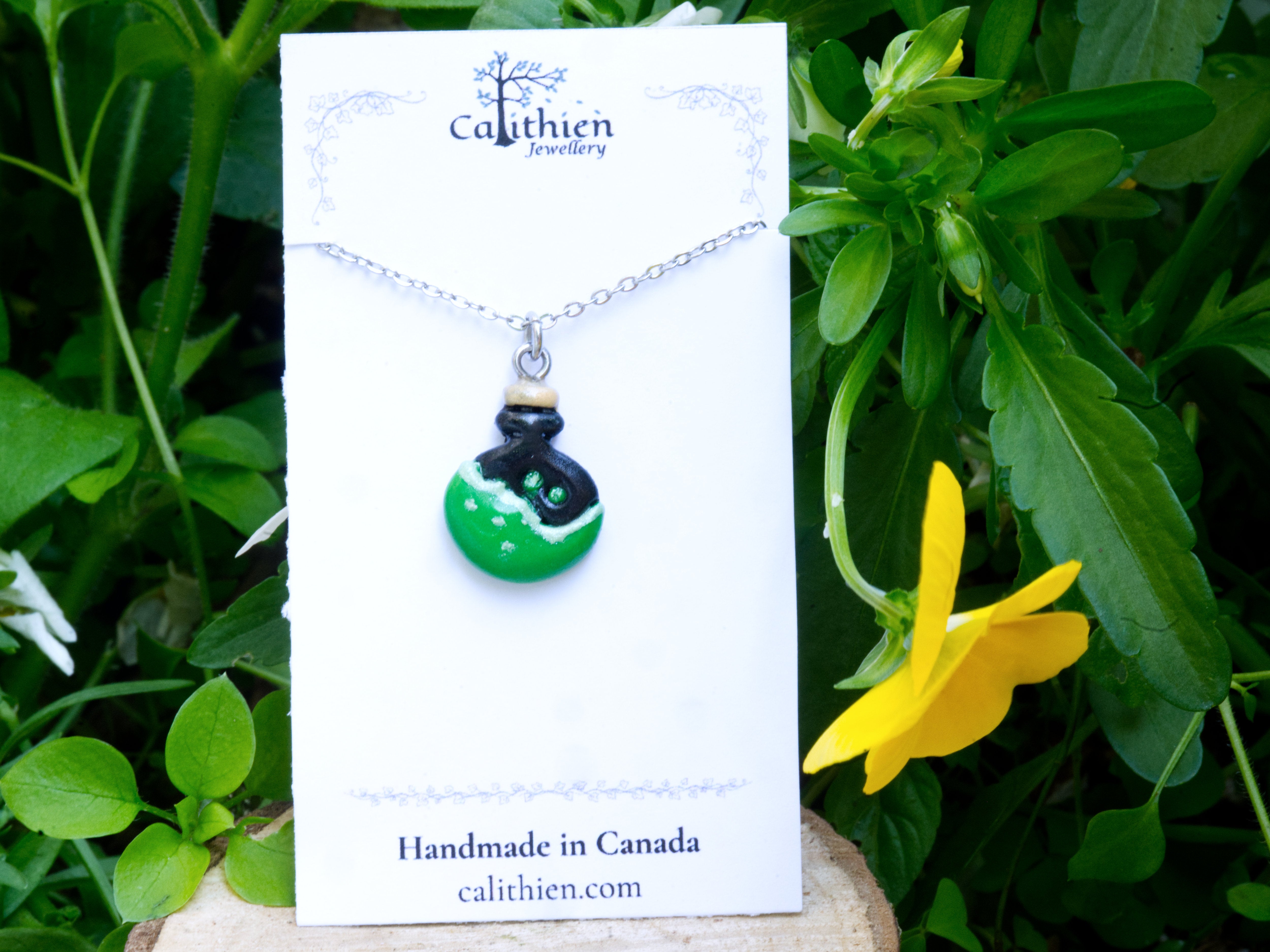Potion bottle pendant necklace on Calithien Jewellery branded display card reading Handmade in Canada