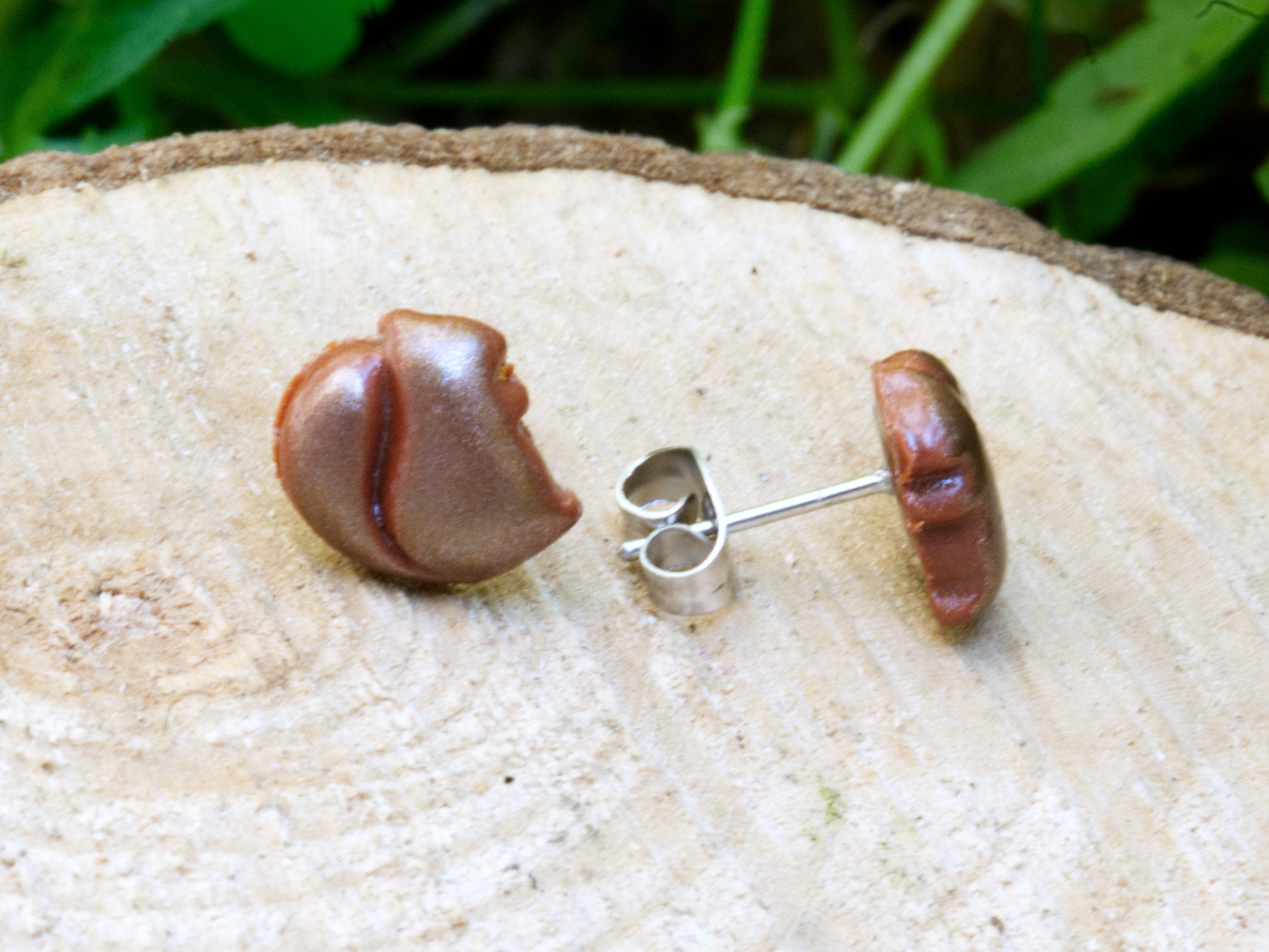 Close-up of brown polymer clay squirrel stud earrings showing hand-sculpted squirrel details and warm shimmer finish