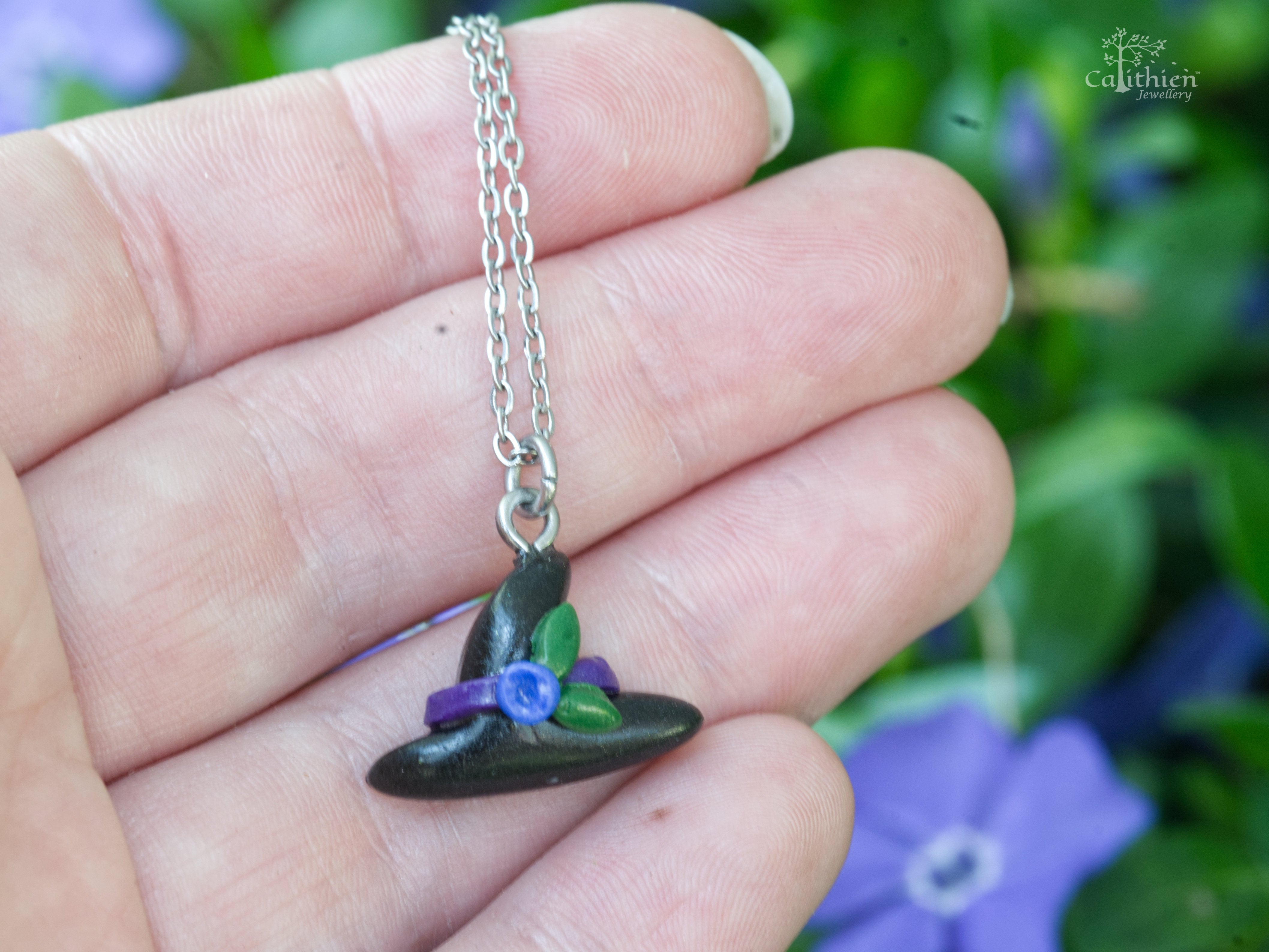Black polymer clay witch hat necklace pendant shown on fingers to demonstrate size