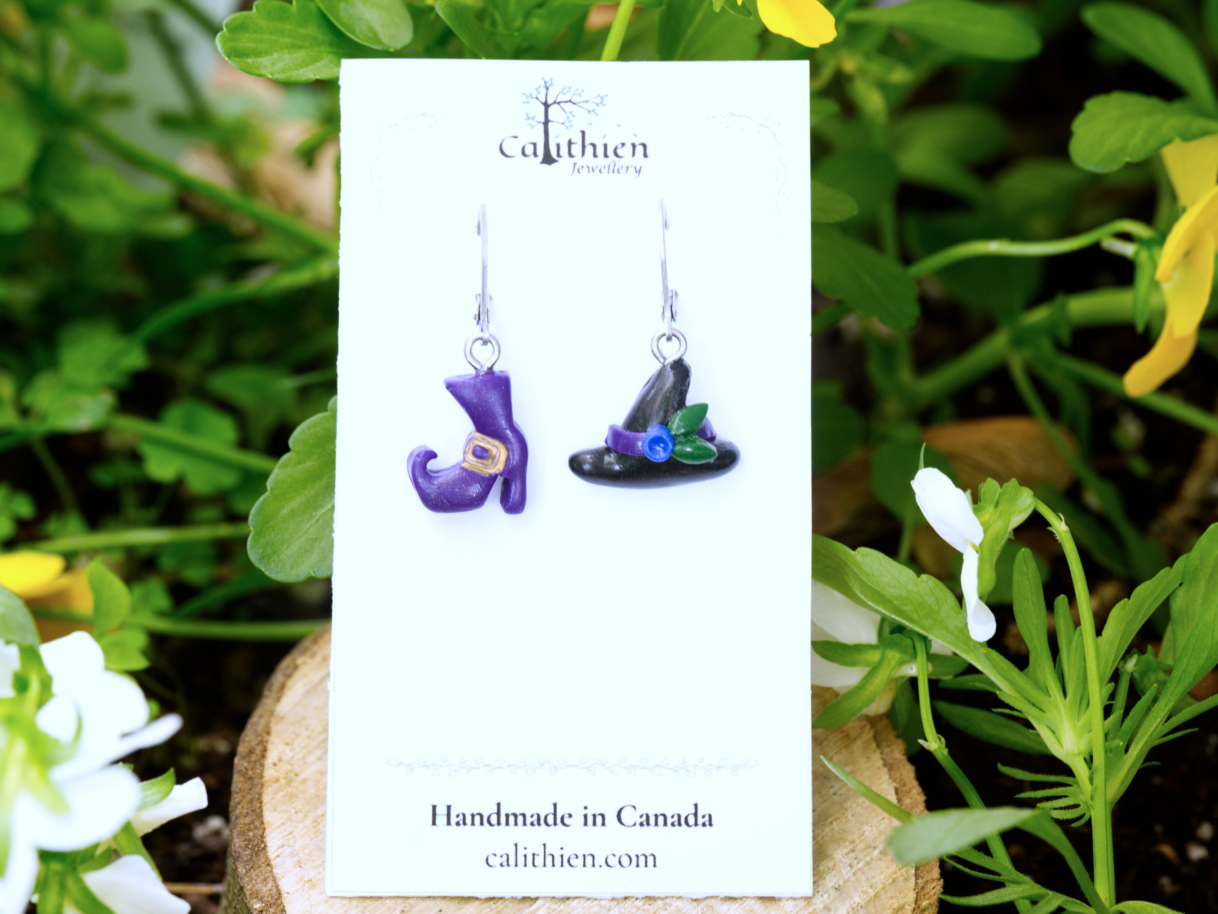 Mismatched witch hat and boot leverback earrings on Calithien Jewellery branded display card reading Handmade in Canada