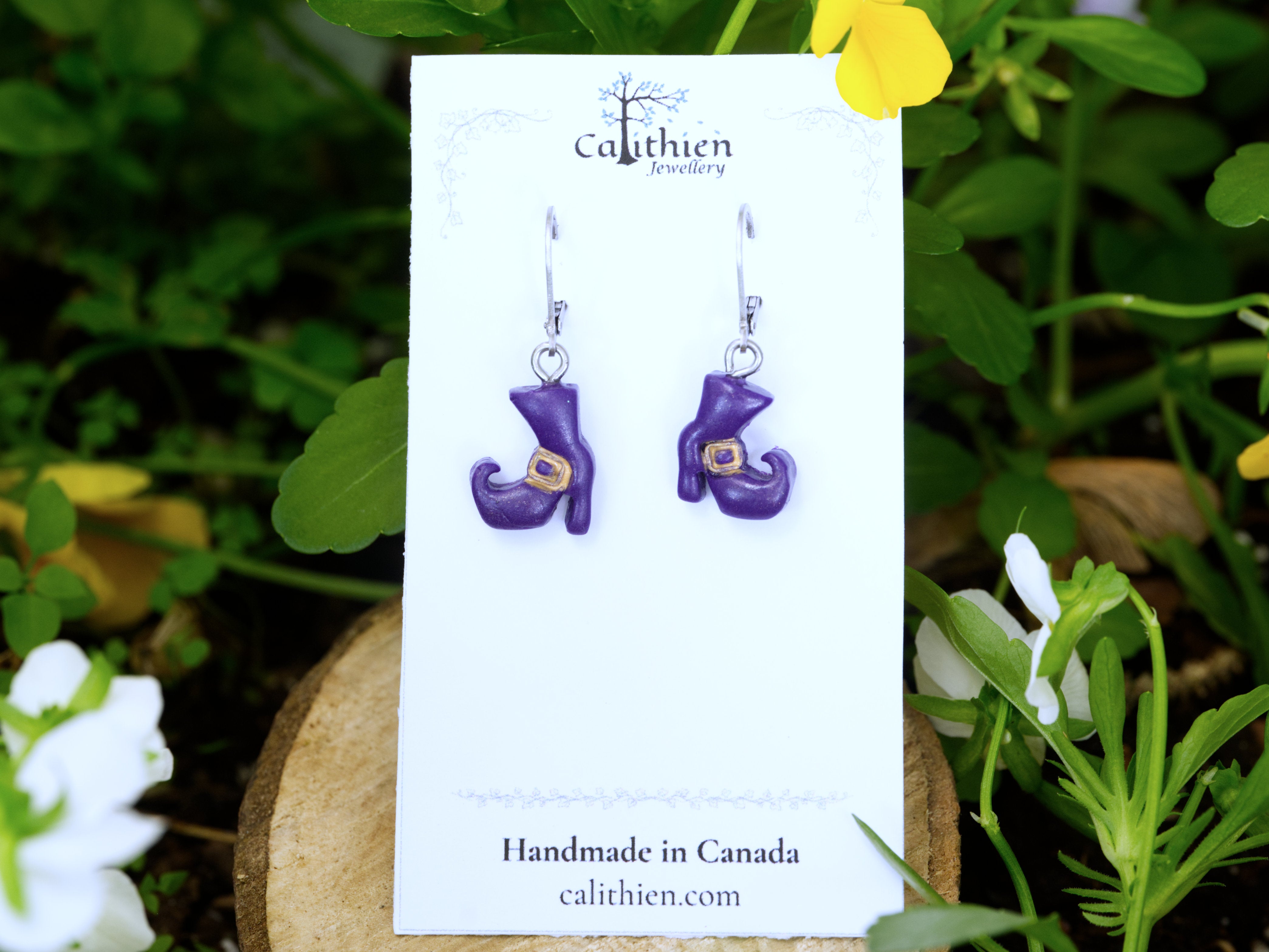 Purple witch boot polymer clay earrings mounted on Calithien Jewellery branded display card reading Handmade in Canada