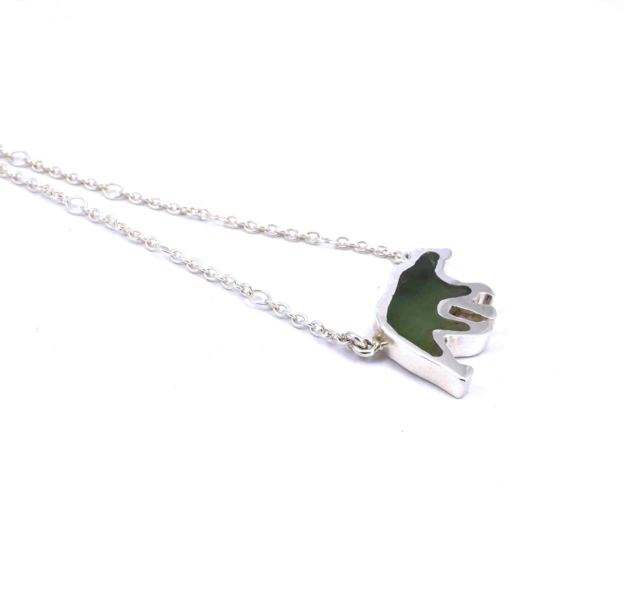 Left side view of sterling silver bear pendant with jade gemstone inlay