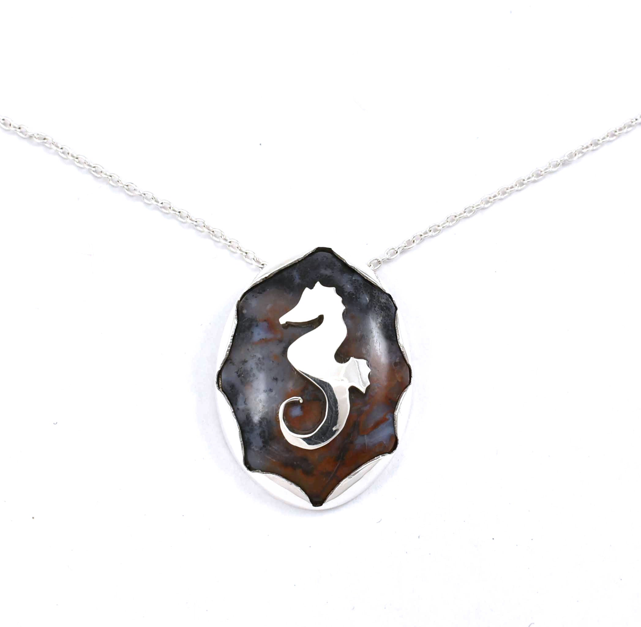 Front view of sterling silver agate pendant with seahorse and fish accents