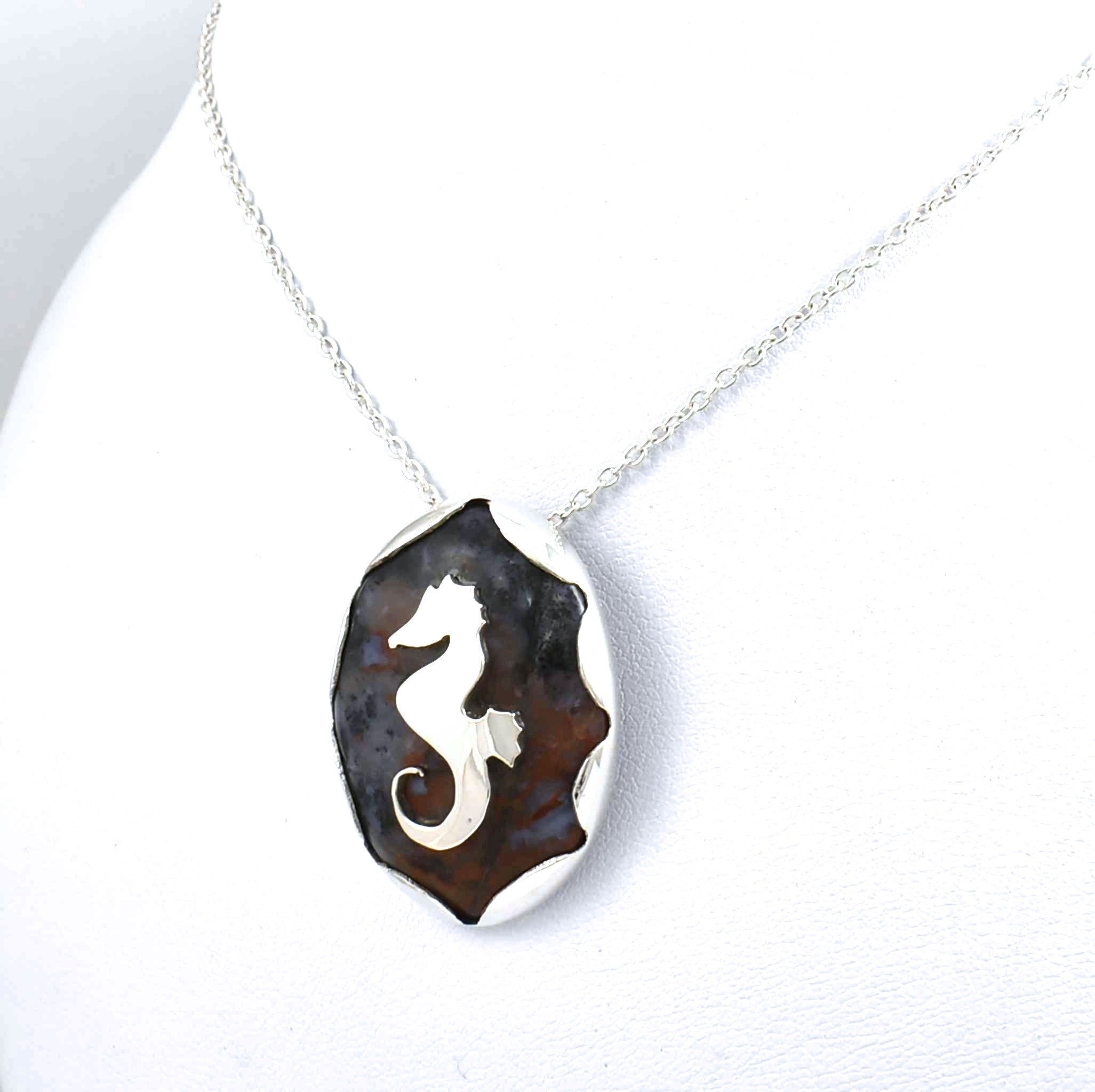 Front view of sterling silver agate pendant with seahorse and fish accents
