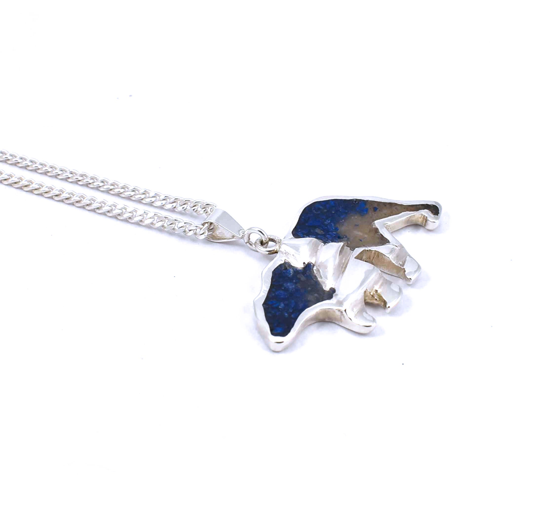 Left side view of medium sterling silver bear pendant with tree accent and crushed gemstone inlay