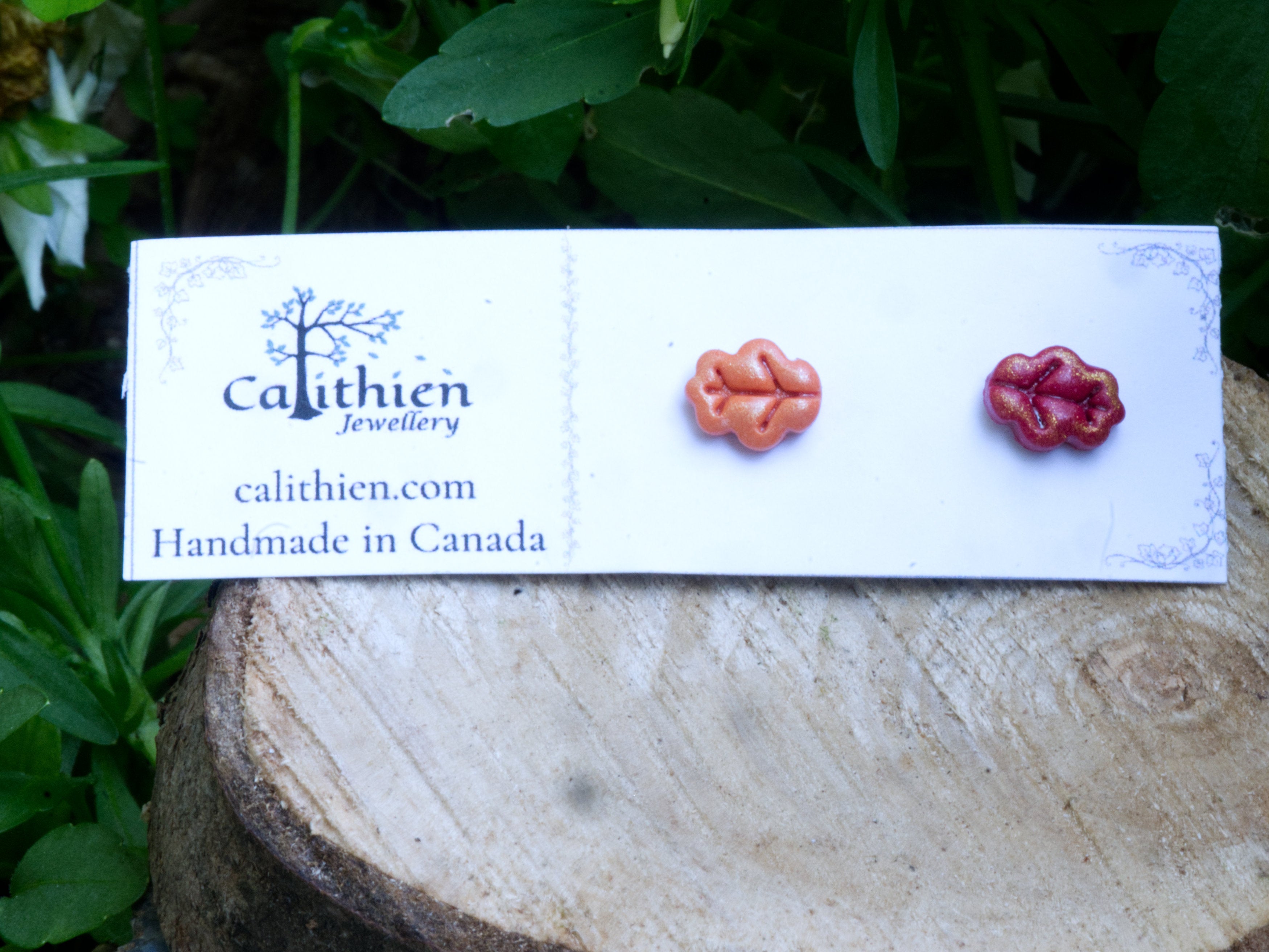 Mismatched oak leaf stud earrings on Calithien Jewellery branded display card reading Handmade in Canada