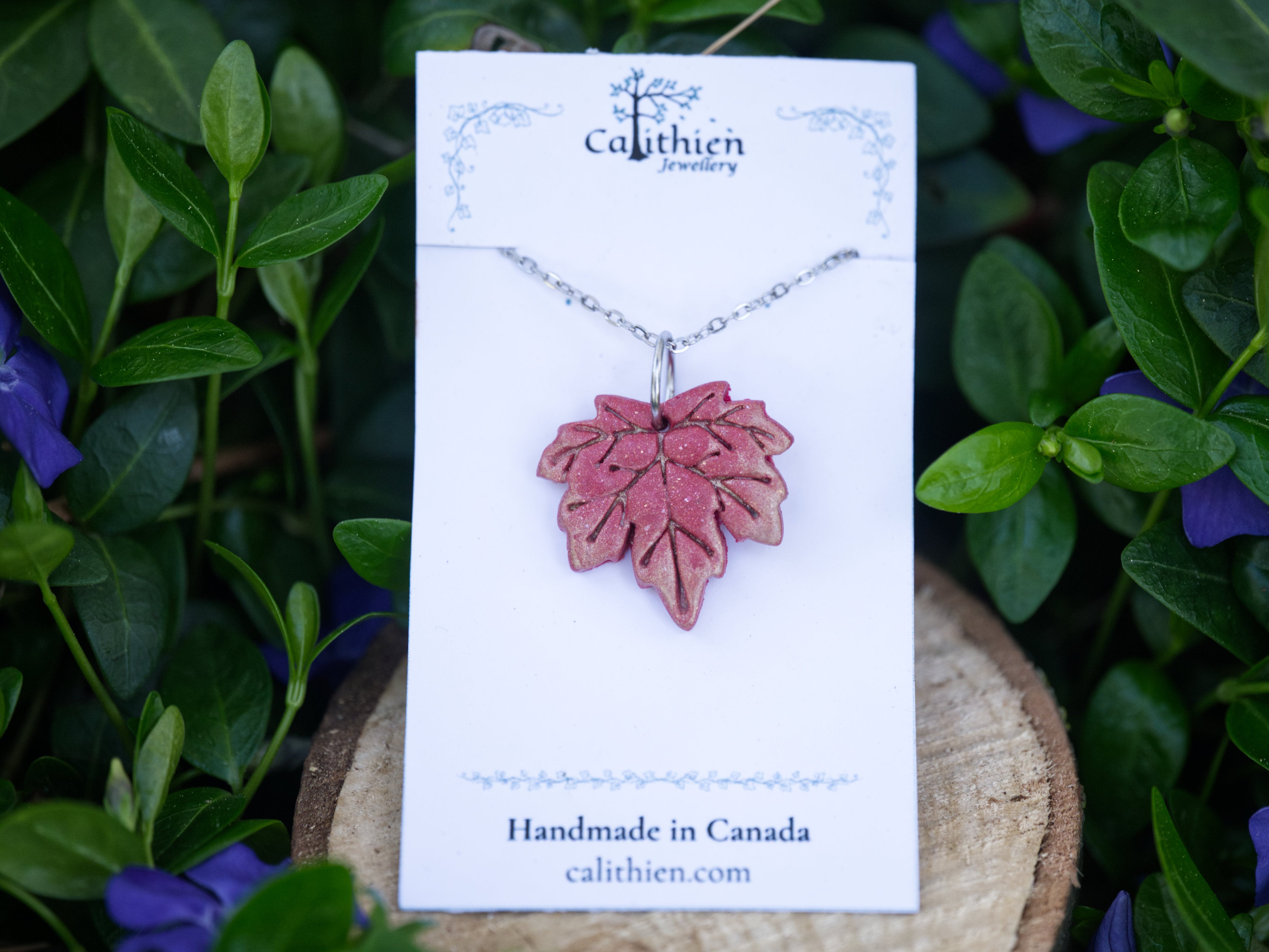 Red maple leaf pendant necklace on Calithien Jewellery branded display card reading Handmade in Canada