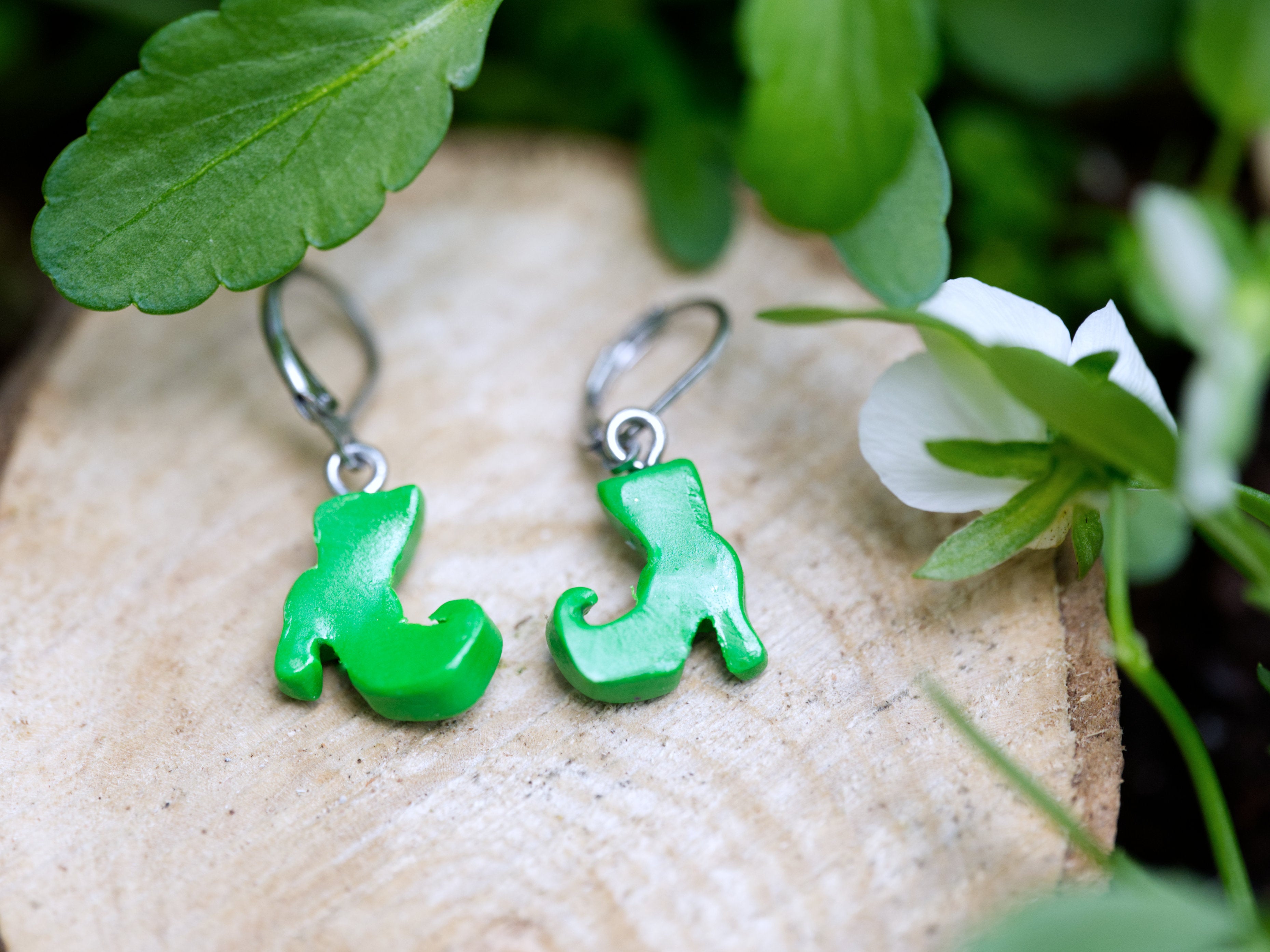 Reverse view of green polymer clay witch boot earring showing satin finish and leverback hook attachment