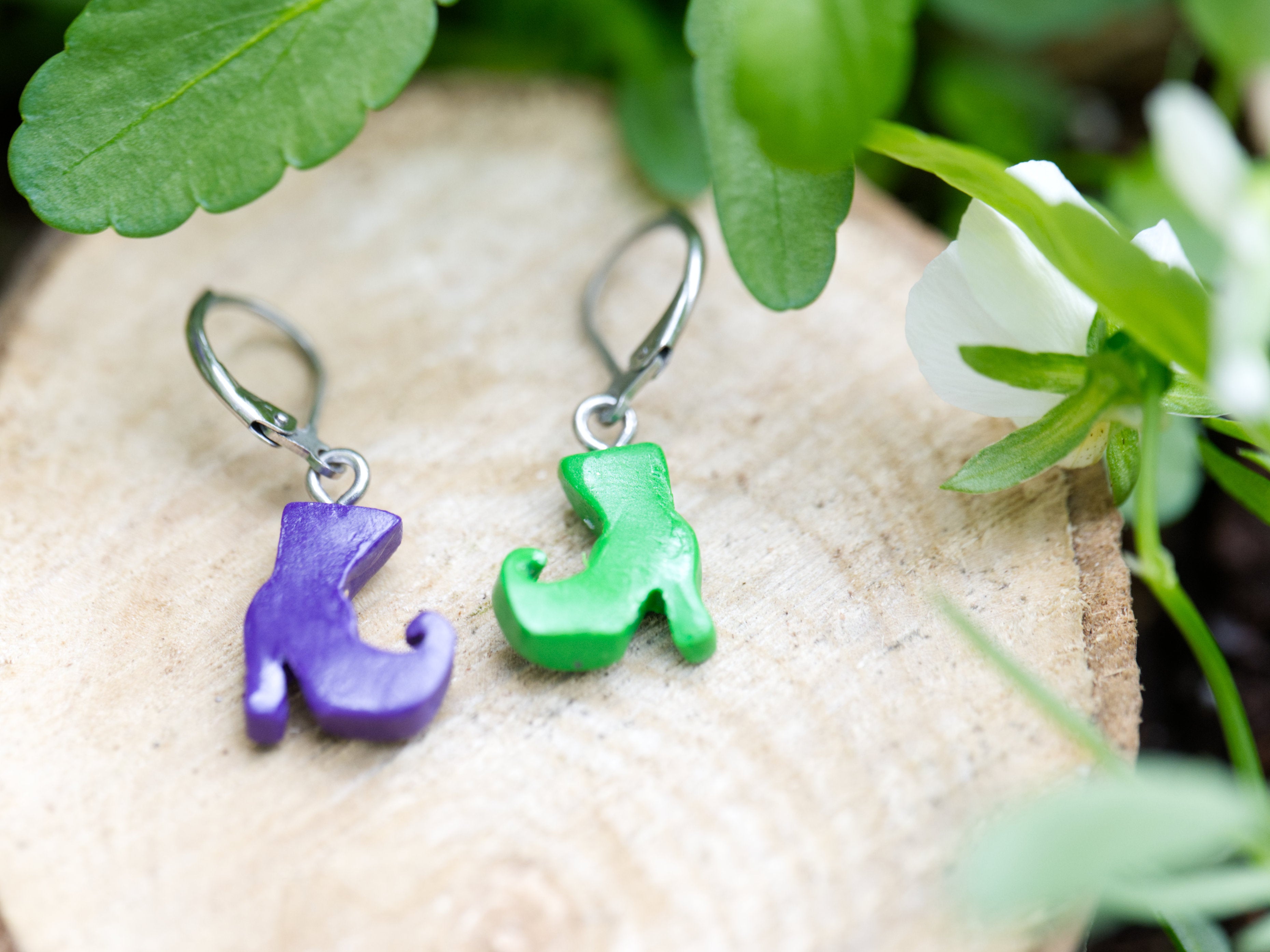 Reverse view of purple and green mismatched polymer clay witch boot earrings showing satin finish and leverback hook attachments
