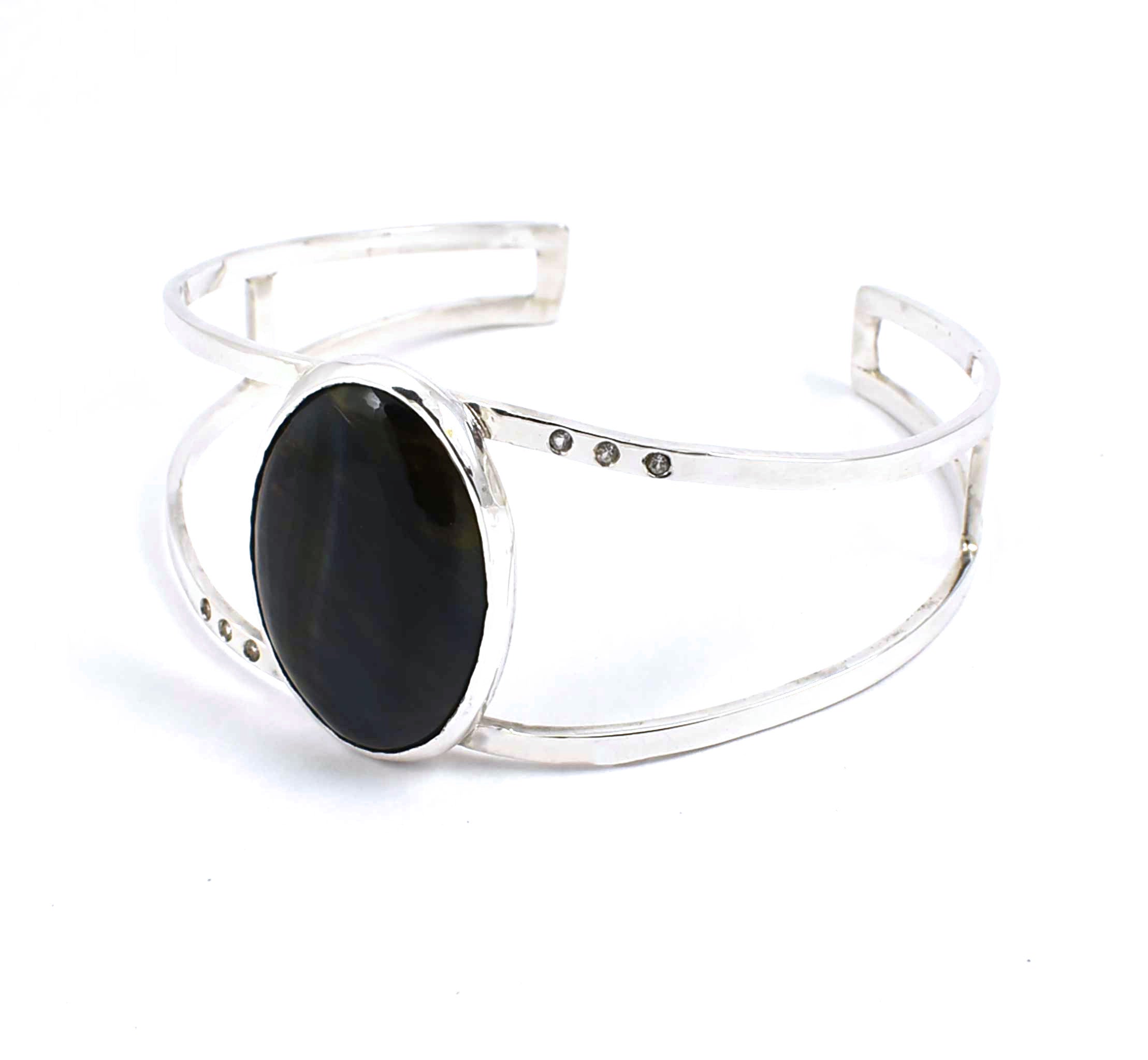 Right side view of sterling silver cuff bracelet with hawk's eye and white sapphires