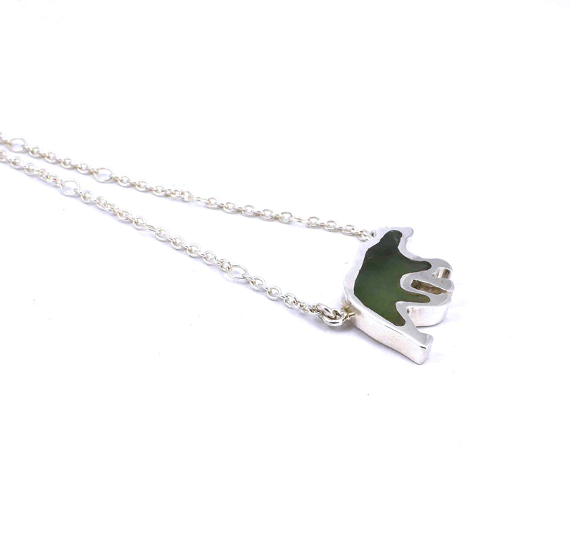 Left side view of sterling silver bear pendant with jade gemstone inlay