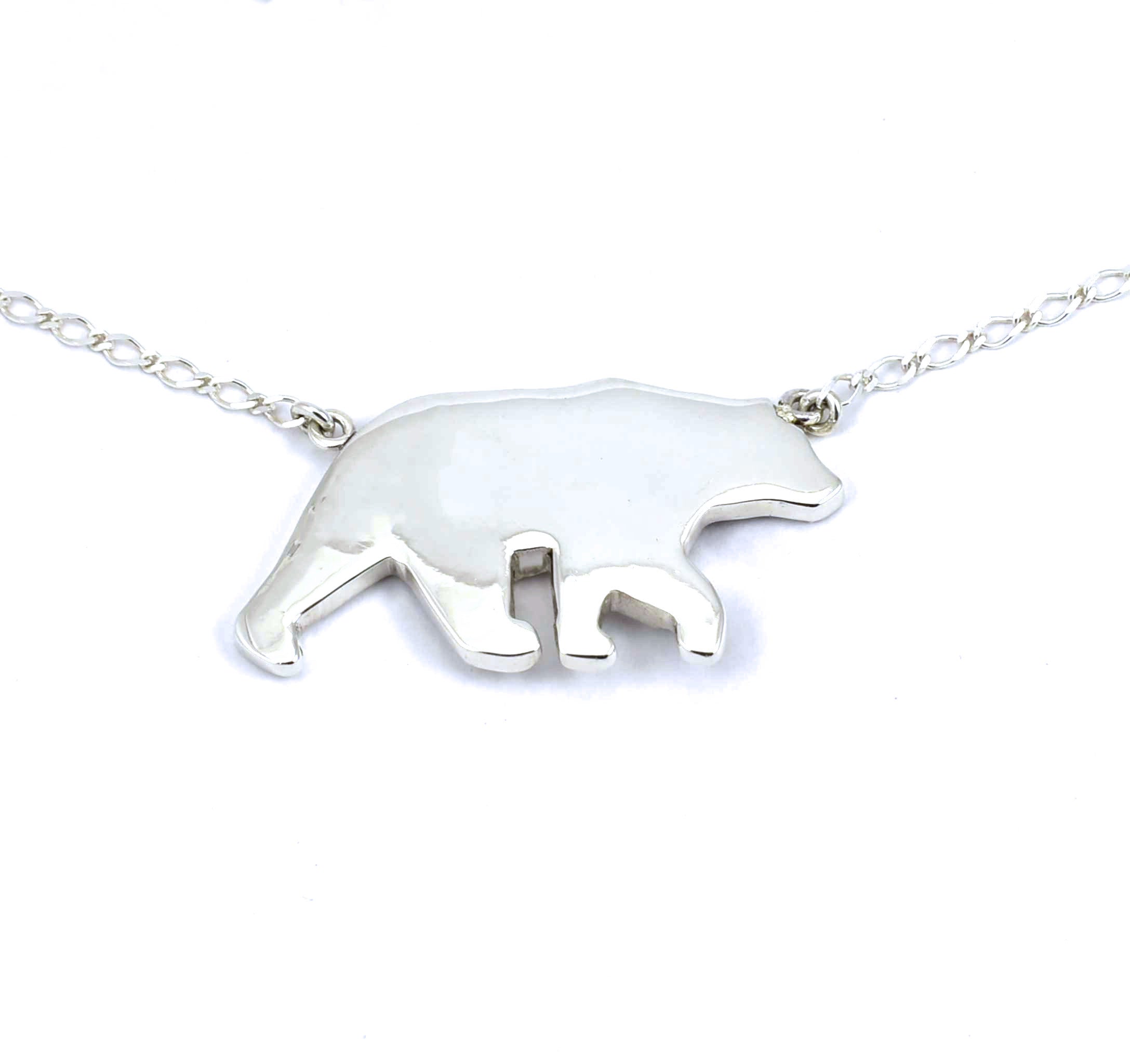 Rear view of large sterling silver bear pendant with tree accents and crushed gemstone inlay