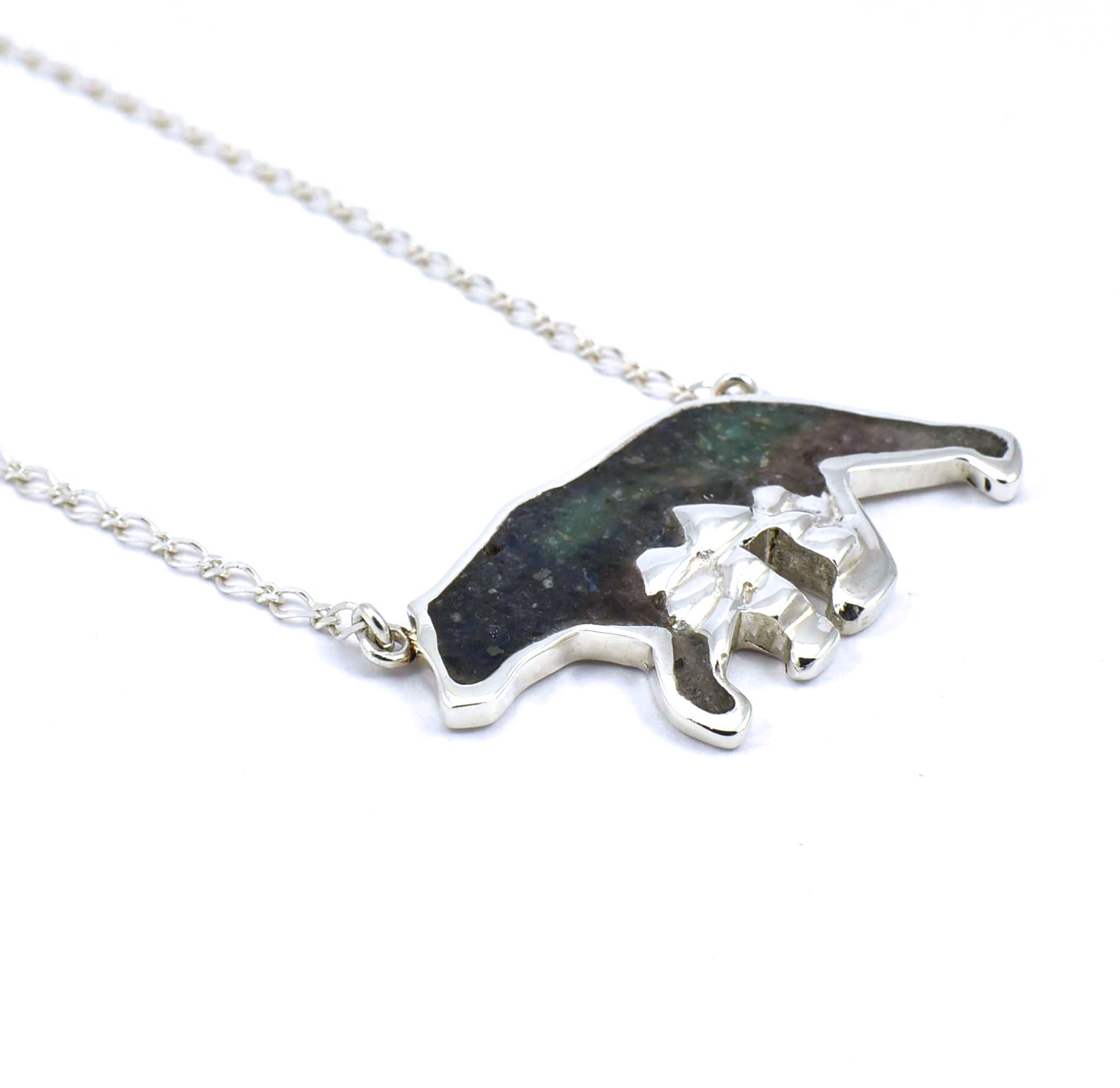 Left side view of large sterling silver bear pendant with tree accents and crushed gemstone inlay